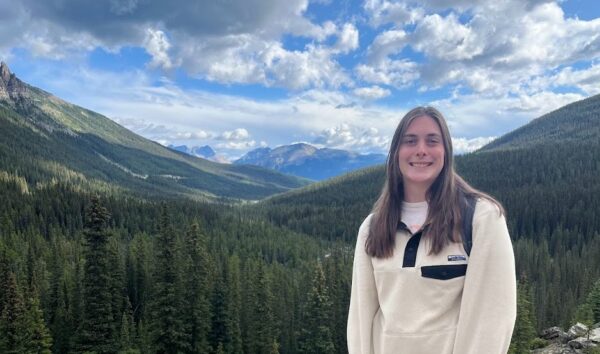 Claire, wearing a fleece, posing in the mountains.
