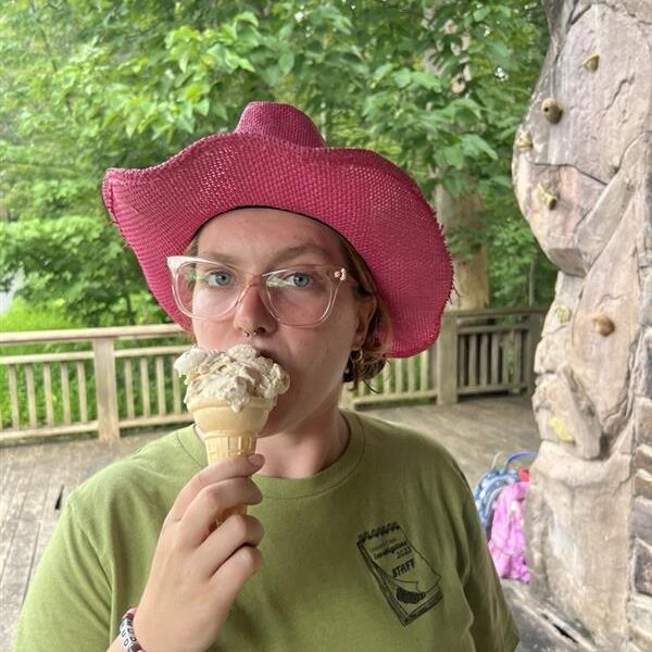 Jamie wearing a pink cowboy hat and eating an ice cream cone.