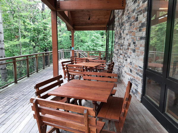 Hamer Deck set up with square wooden tables and wooden benches on all sides of each table.