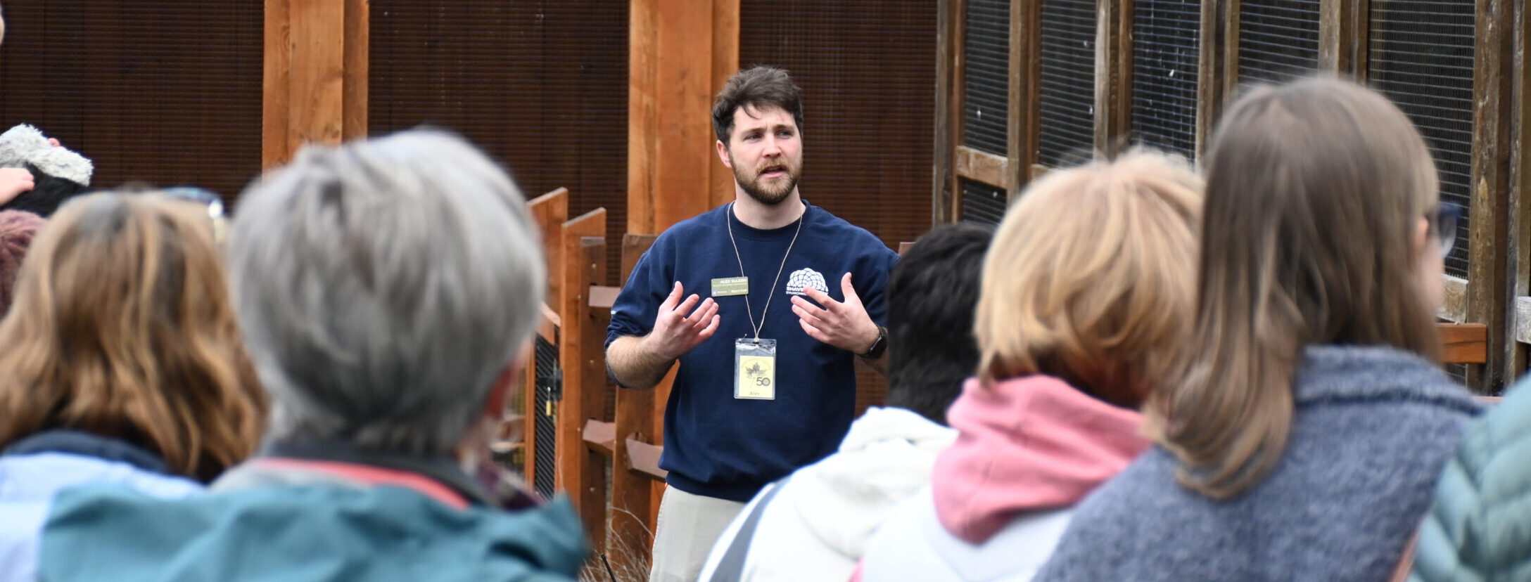 Someone speaking in front of a group of people in an outdoor setting