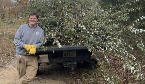 Casey Pittrizzi leaning on a flatbed truck with brush