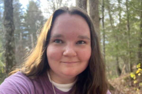 Lindsay smiling in the forest.