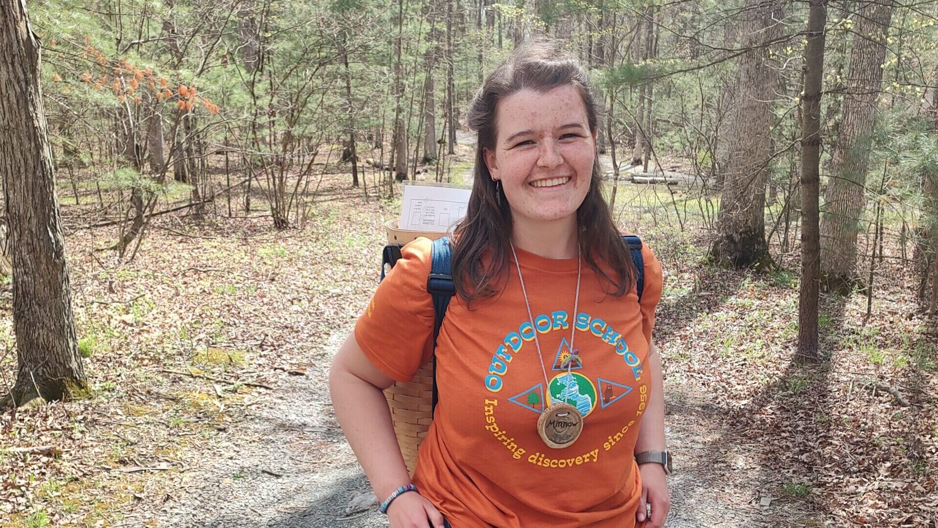 Mara wearing an orange Outdoor School tshirt.
