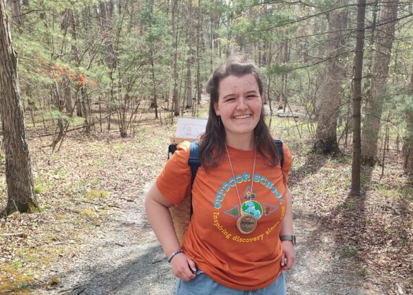 Mara wearing an orange Outdoor School tshirt.