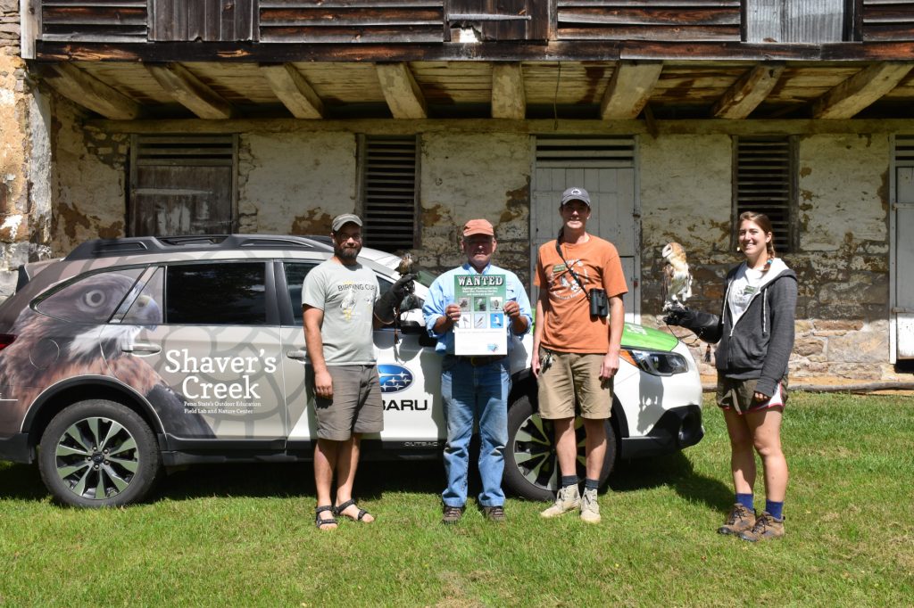 Farmland Conservation volunteers pose with a barn owl in front of the Shaver's Creek Subaru