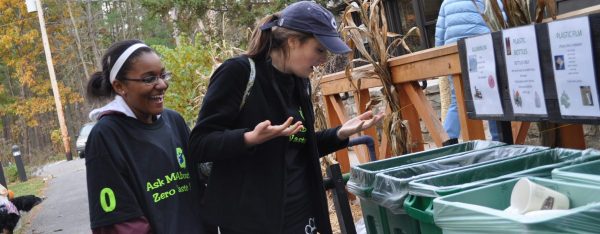 Two Zero Waste workers puzzle over the contents of the recycling bins