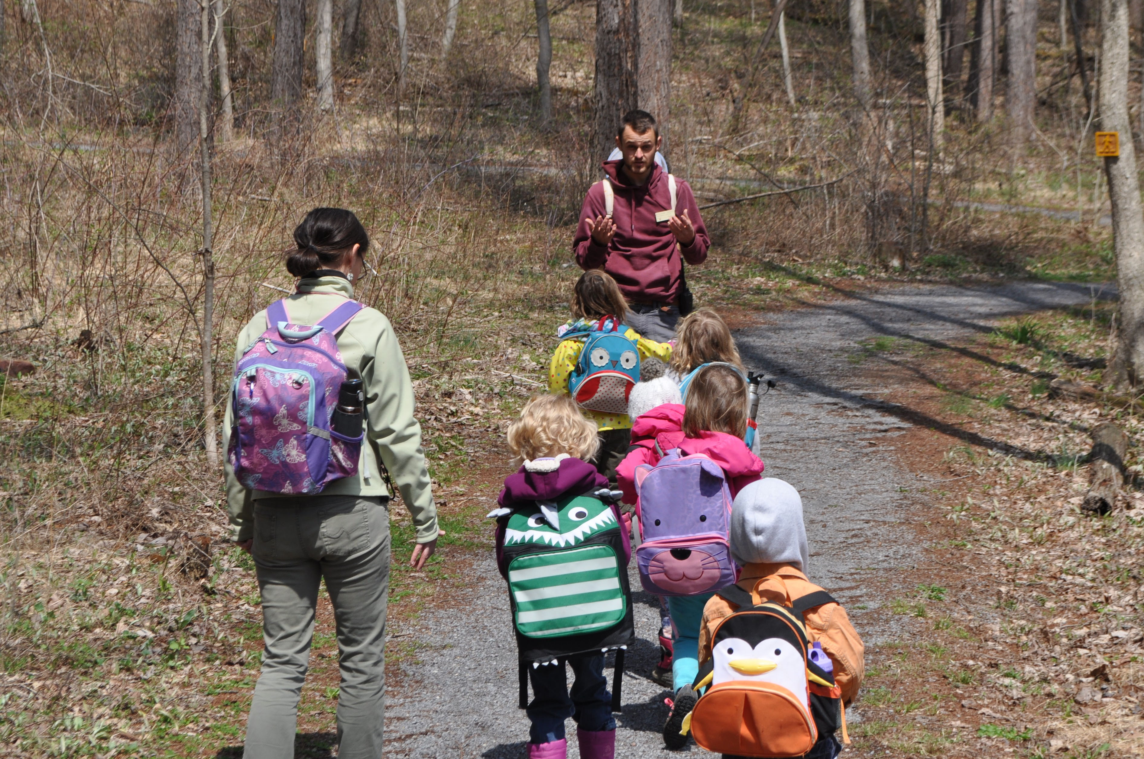 Counselor and kids hiking on a trail