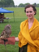 A woman in a Renaissance era costume holding an owl
