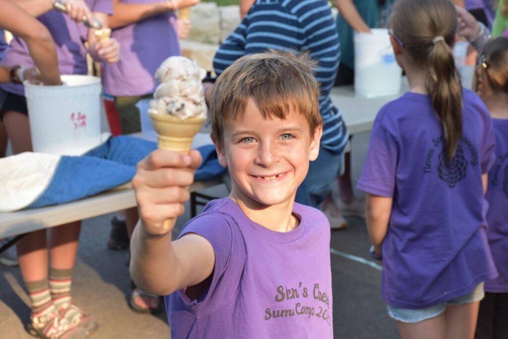 Image of a smiling camper holding ice cream