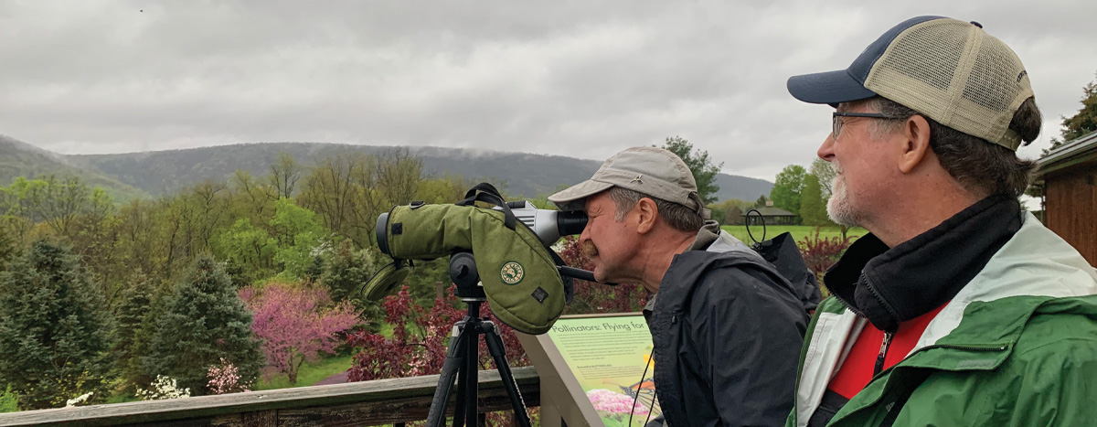 Two people looking through spotting scopes