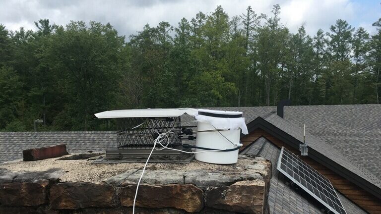 A microphone attached to a white bucket sits on the roof of Shaver's Creek's visitor center to record the sounds made by migrating birds.