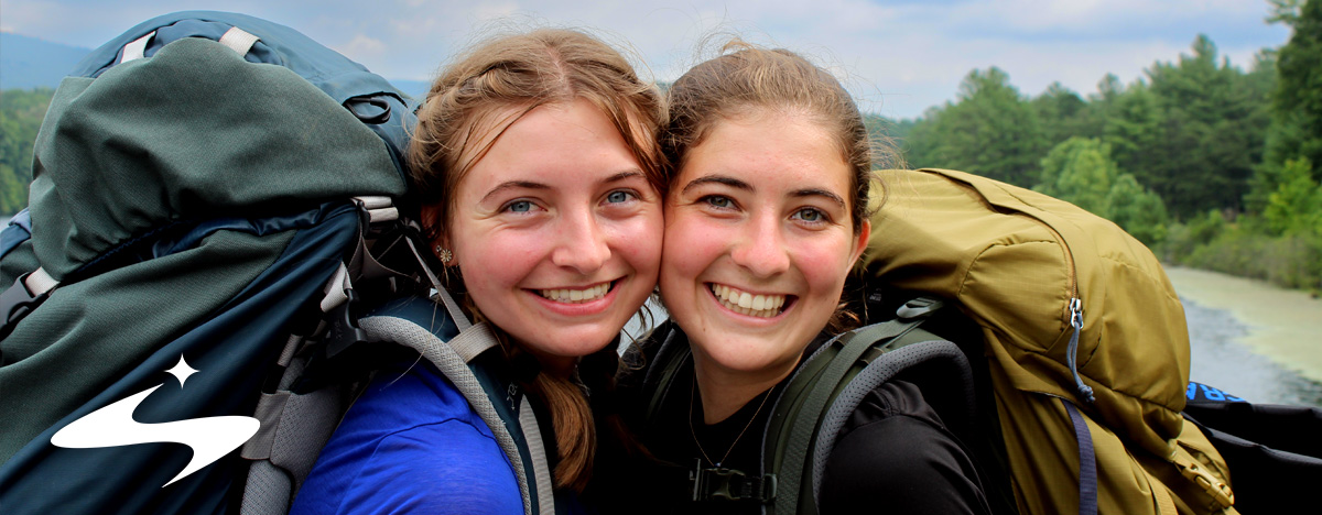 Two students pose together during a backpacking trip