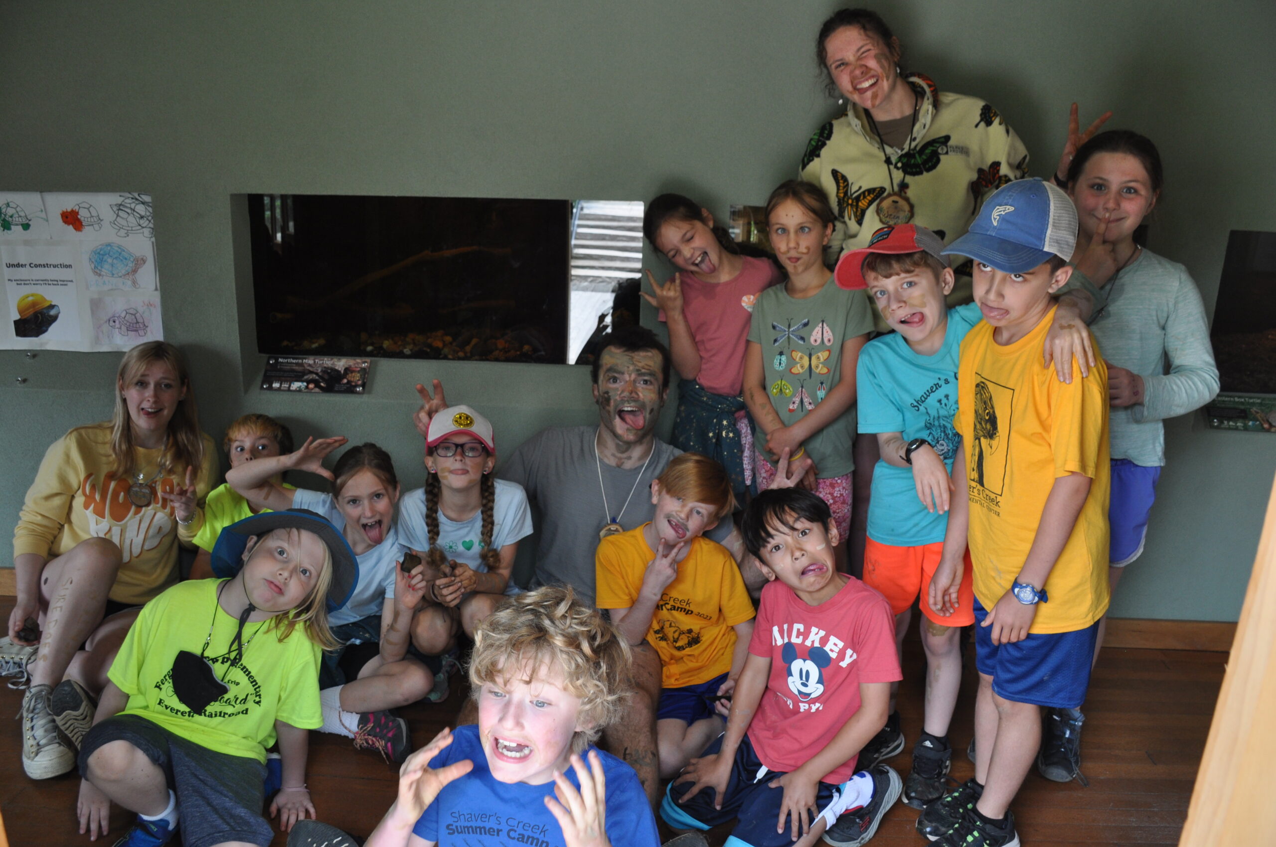 A group of summer campers make silly faces while posing for a picture.