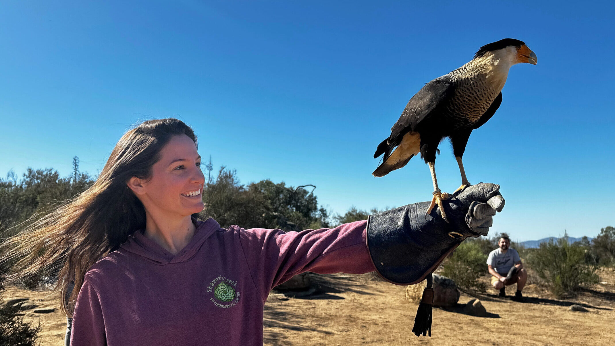 Paige Sutherland with a raptor on her gloved hand.