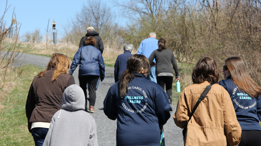 Students and faculty from the Ross and Carol Nese College of Nursing walk on the gravel path in Musser Gap Greenway.