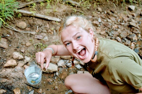 Hannah smiling while holding a crayfish.