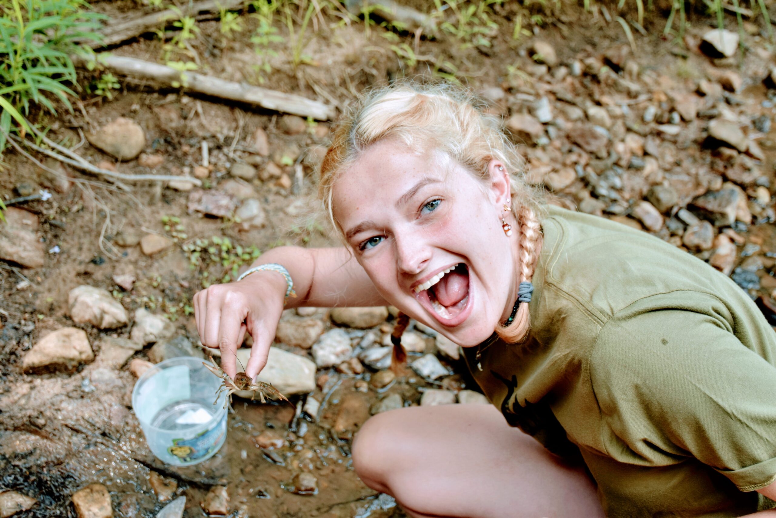 Hannah smiling while holding a crayfish.