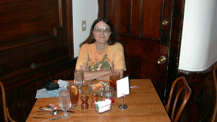 Denise sitting at a dinner table.