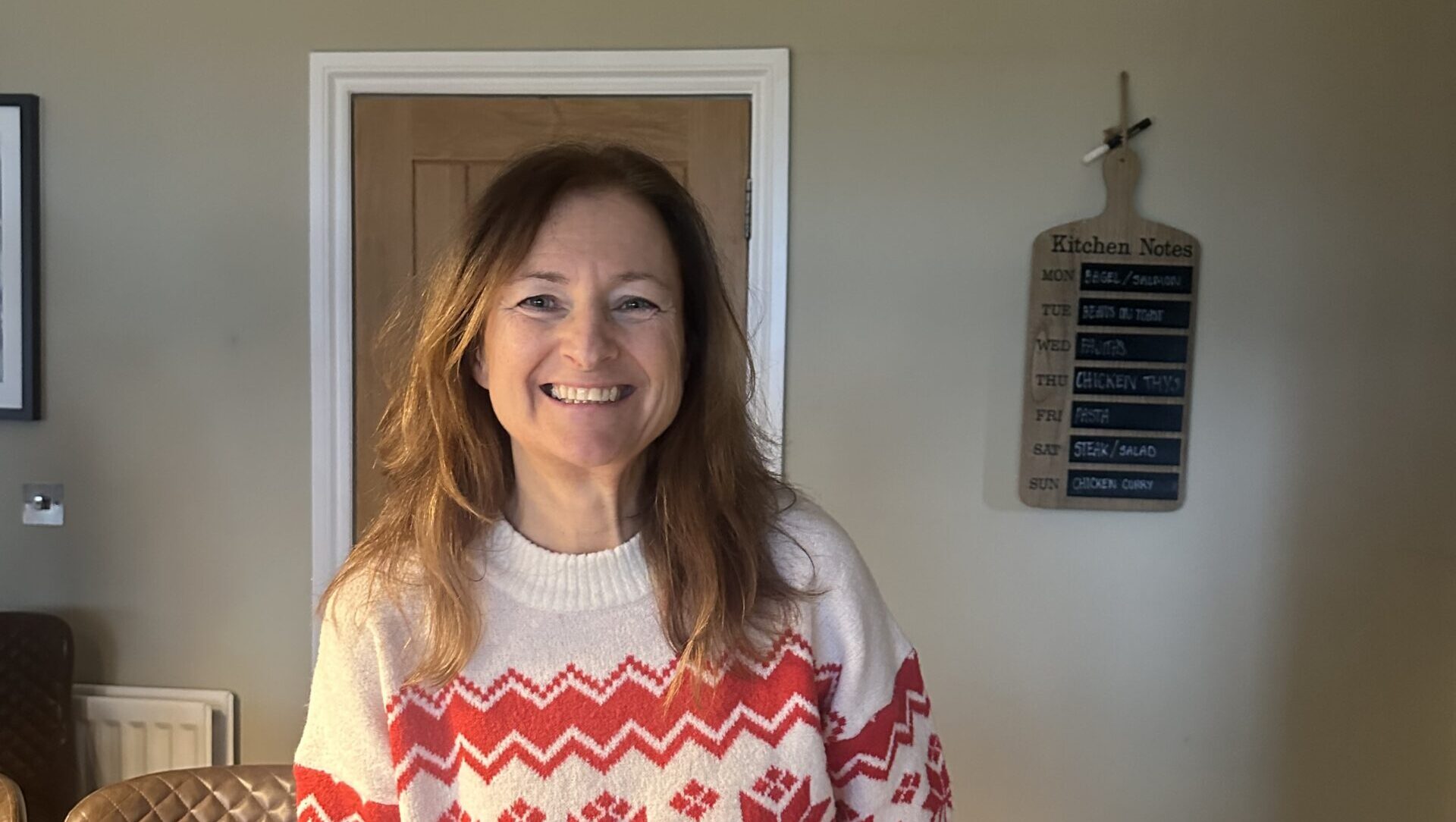 Sarah in a red and white knitted sweater.