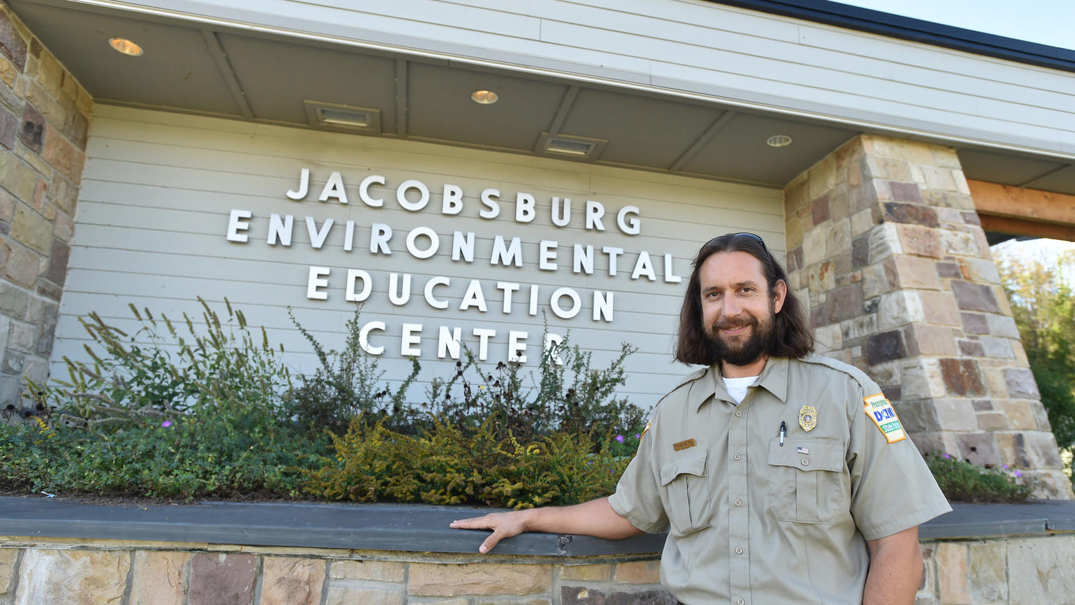 Rob standing in front of a sign that says Jacobsburg Environmental Education Center