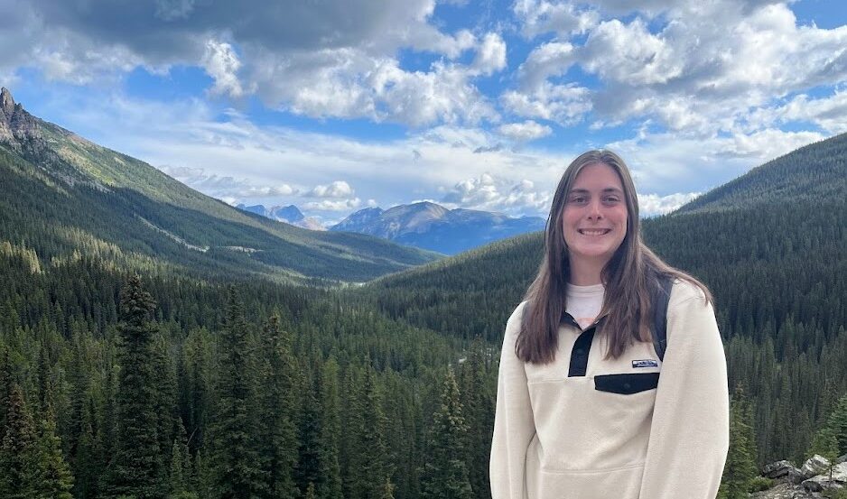 Claire, wearing a fleece, posing in the mountains.