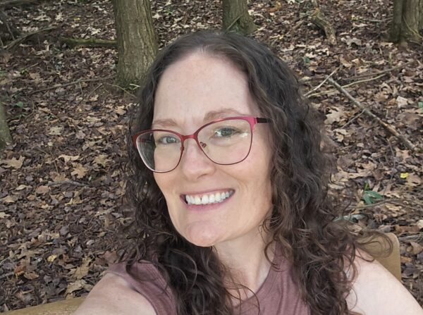 Heather sitting on a park bench and smiling.