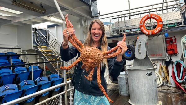 Zoey smiling and holding a giant crab