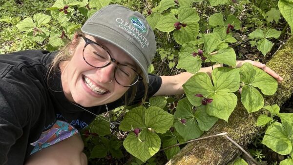 Bridget crouches for a photo among trillium leaves.