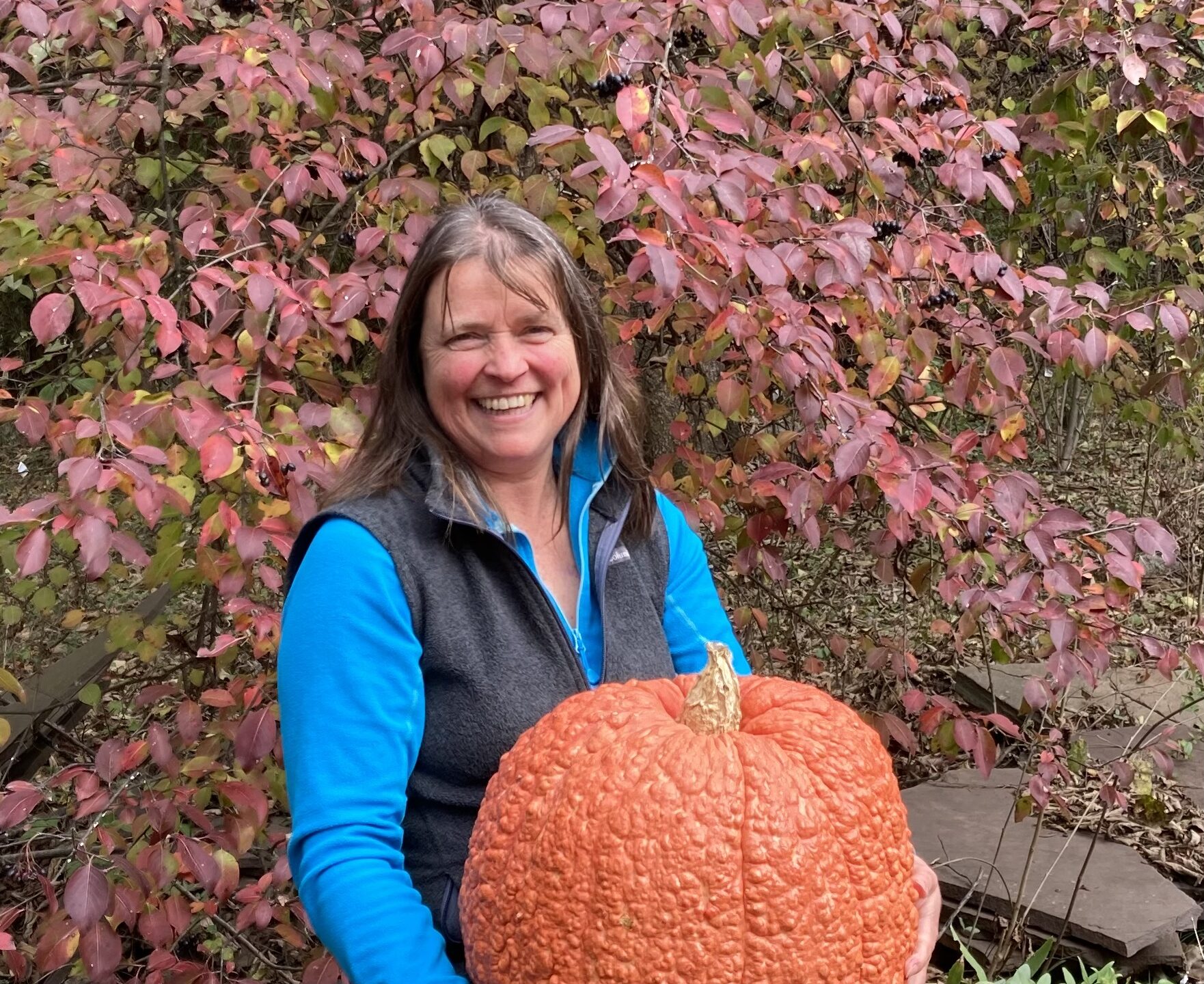 Kristin holding a giant pumpkin.
