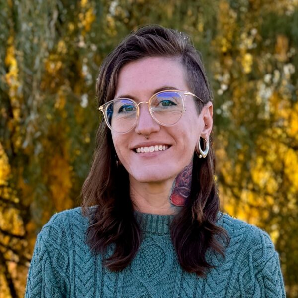 Aubrey posing in front of a wooded background
