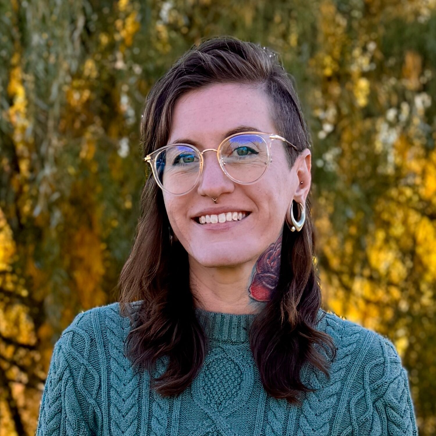 Aubrey posing in front of a wooded background