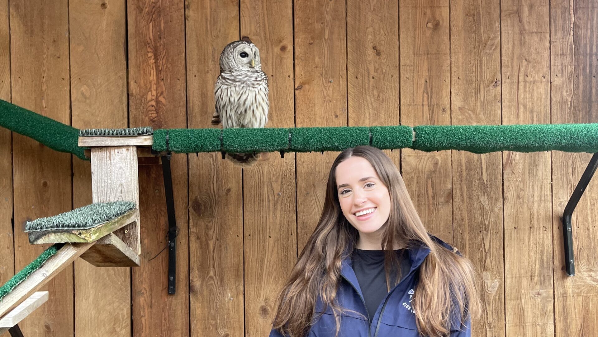Allie posing in an enclosure with a small owl.