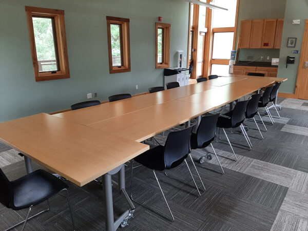 Conference setup in the Aerie Classroom with one large conference table with chairs on all sides.