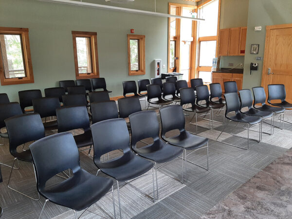 The Aerie Classroom with no tables and rows of chairs, all facing the front of the room.