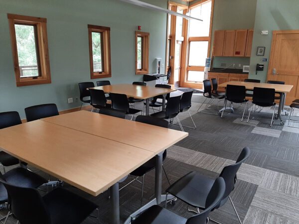 The Aerie Classroom set up with square tables and chairs on all sides of the tables.