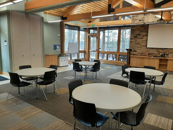 Hamer Classroom set up with 4-foot-diameter tables and chairs around each table.