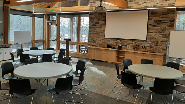 Hamer Classroom set up with round tables surrounded by chairs.