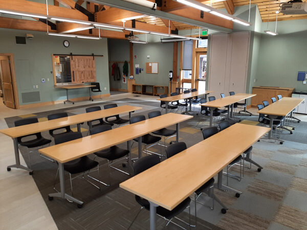 Hamer Classroom set up with long tables in rows and all chairs facing the front of the classroom.