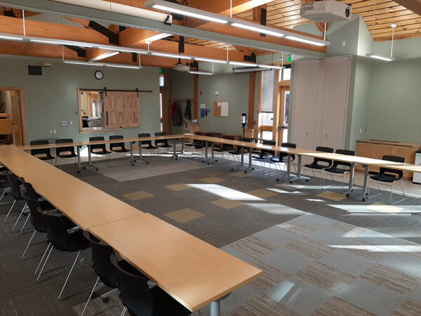 Hamer Classroom set up with long tables in a U shape and chairs on the outside of the U.
