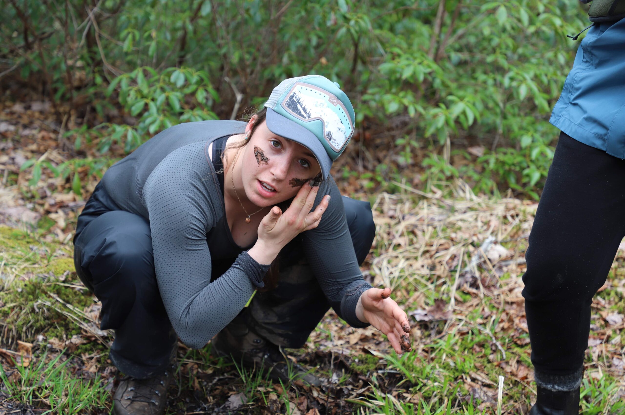 Autumn crouching in the dirt to smear a line of mud under each eye.