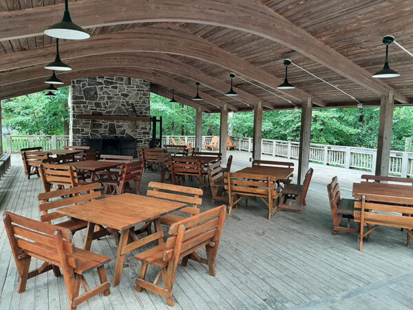 The Outdoor Classroom set up with square wooden tables with wooden benches around each table.