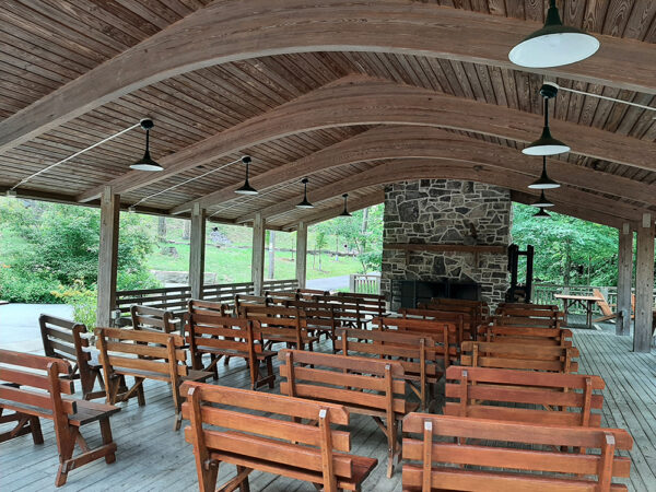 The Outdoor Classroom set up theater style with wooden benches in rows, facing the front of the classroom.