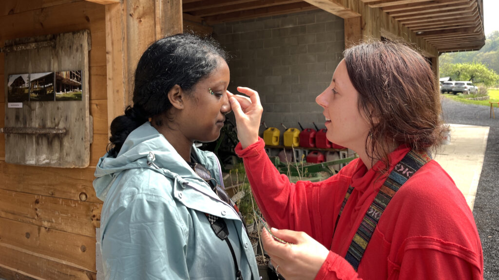 Autumn applies jewel stickers to Jasmine.