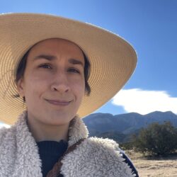 Jennifer Brown with mountains and a clear blue sky in the background