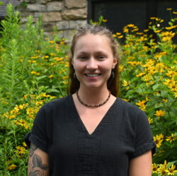 Shelby standing in front of flowering black-eyed susans.